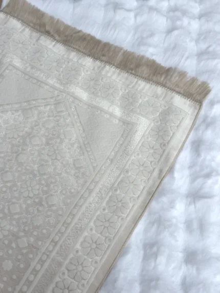 Ein Gebetsteppich mit glänzender Struktur in der Farbe crema